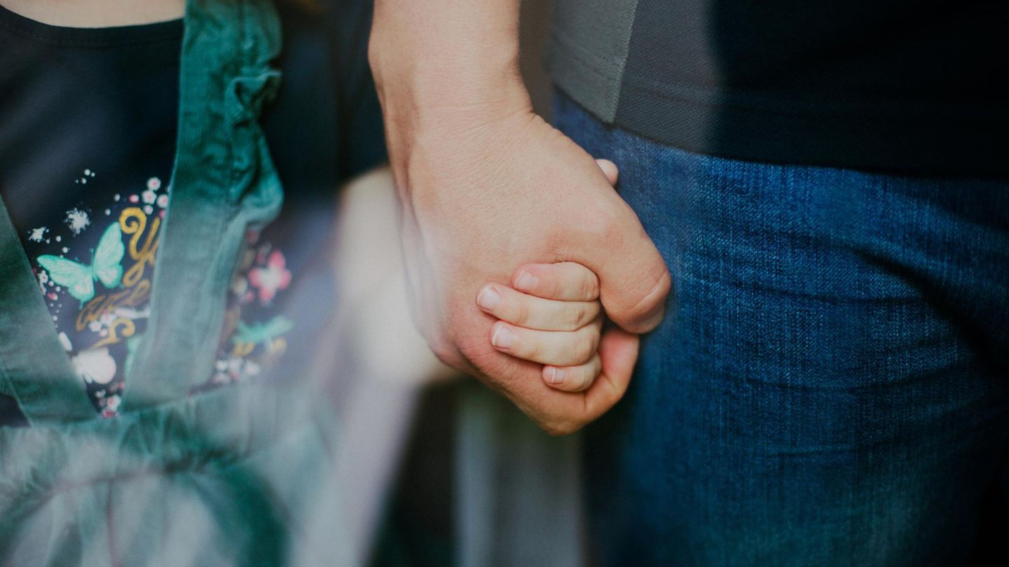 Ein Vater hält die Hand seiner Tochter (Symbolbild Patchwork-Familie) Ein Vater hält die Hand seiner Tochter (Symbolbild Patchwork-Familie)