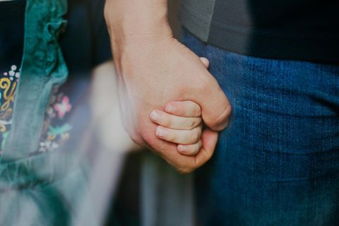 Ein Vater hält die Hand seiner Tochter (Symbolbild Patchwork-Familie)