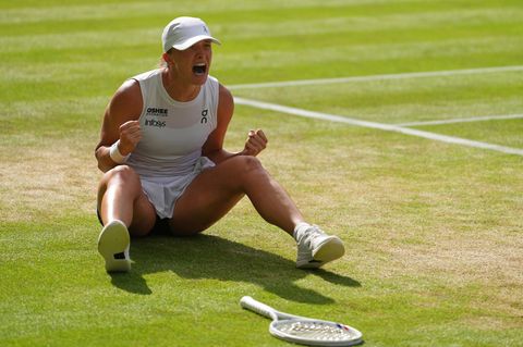 Nach ihrem Sieg in Wimbledon sitzt Iga Swiatek jubelnd auf dem Boden