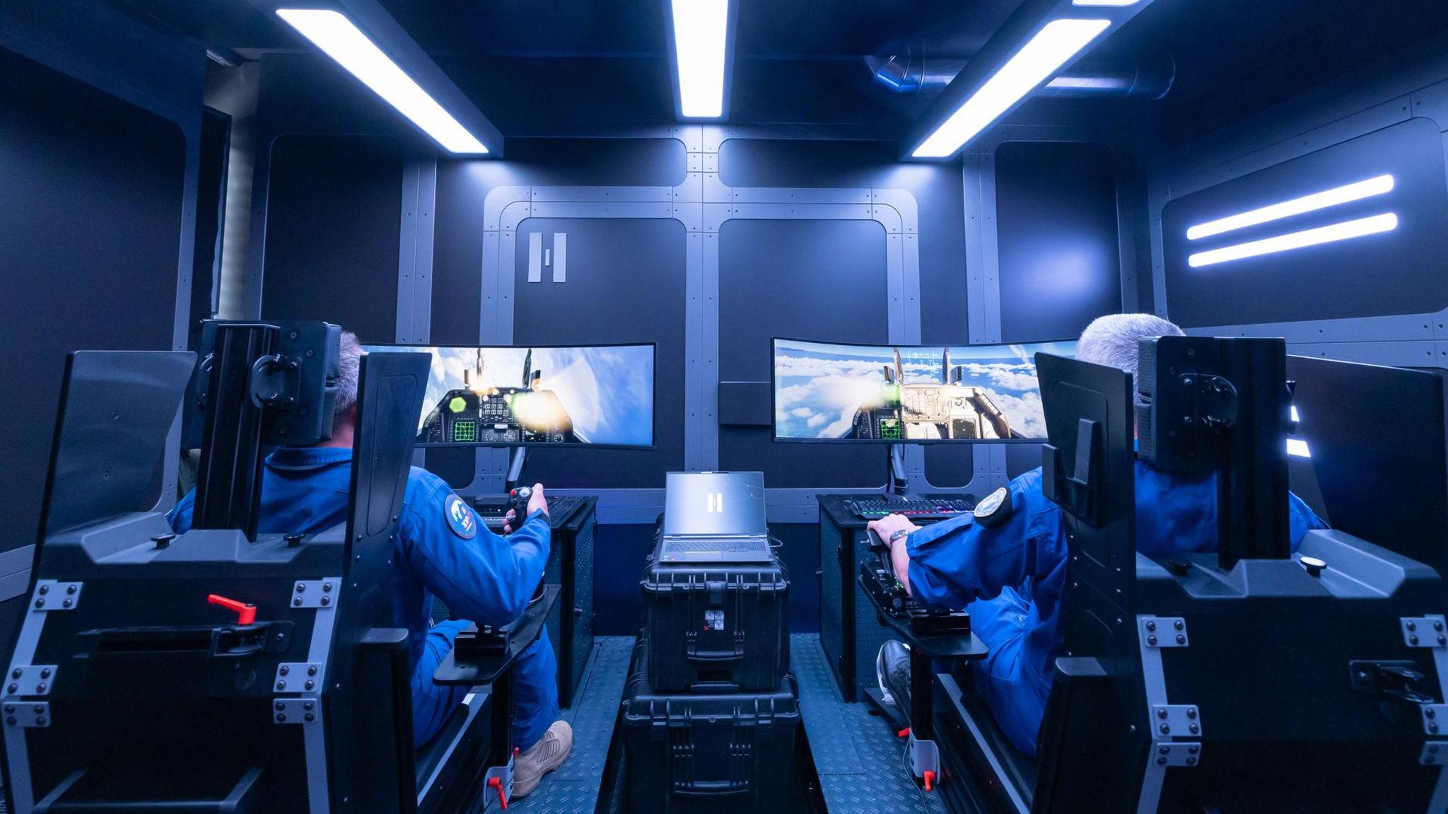 Zwei Helsing-Kampfpiloten sitzen am Flugsimulator in einem futuristisch gestalteten Raum