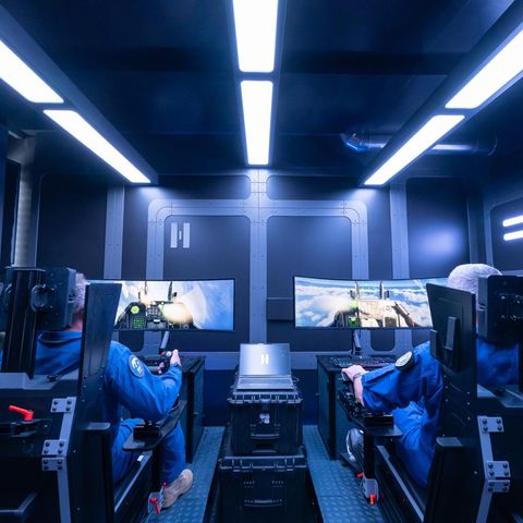 Zwei Helsing-Kampfpiloten sitzen am Flugsimulator in einem futuristisch gestalteten Raum