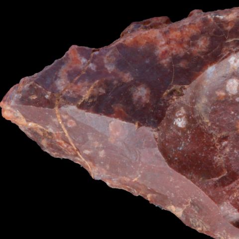 Steinzeitmensch Rotes Steinwerkzeug