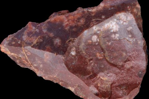 Steinzeitmensch Rotes Steinwerkzeug