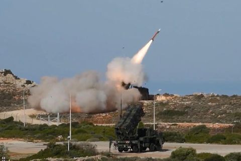 Eine Rakete startet, im Vordergrund ein Militärfahrzeug