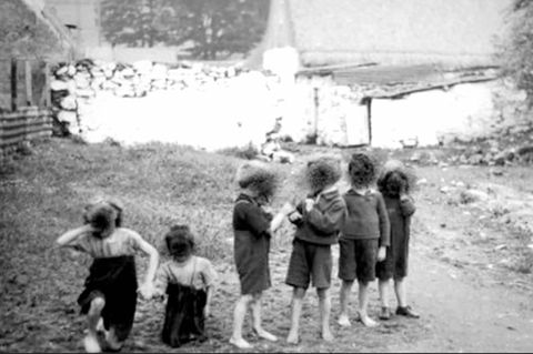 ein altes schwarz-weiß Foto zeigt sechs kleine Kinder vor einem See