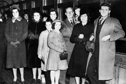 Familienoberhaupt Joseph P. Kennedy mit acht seiner neun Kinder, aufgenommen in New York am 23. Februar 1938: Patricia, Kathleen, Eunice, Robert, Jean, Joseph Sr., Edward, Rosemary und Joseph Jr. (v. l. n. r.). Nicht im Bild: John F. Kennedy, der spätere US-Präsident