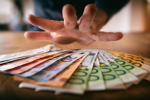 Influencer: Hand greift nach Geldscheinen