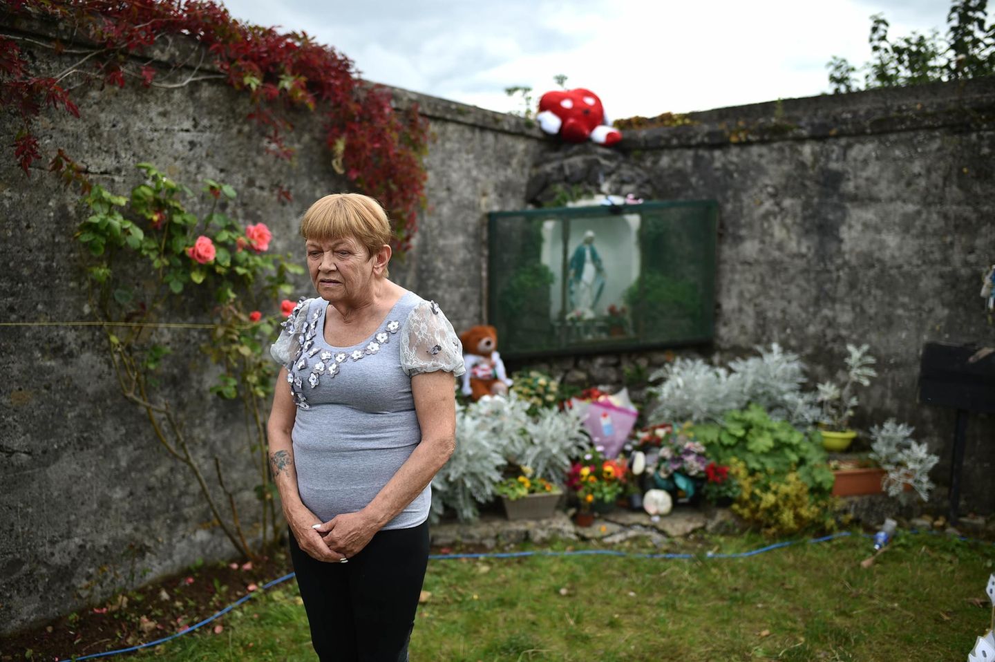 Ann O'Gorman wurde im Mutter-und-Kind-Heim in Tuam geboren. Bei einer Mahnwache für fast 800 Kinder, die in dem Heim starben, posiert sie vor dem Schrein, unter dem ein Massengrab vermutet wird