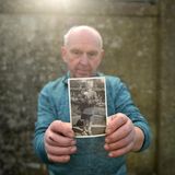 P.J. Haverty hält ein Kinderfoto in die Kamera