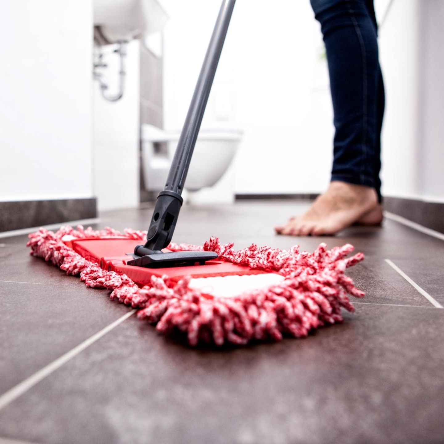 Woman wiping the floor in bathroom