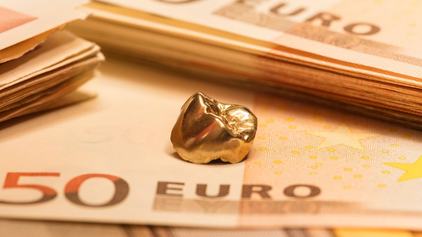 Goldener Zahn liegt auf 50-Euro-Scheinen