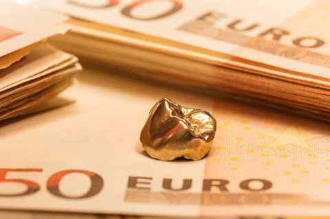Goldener Zahn liegt auf 50-Euro-Scheinen