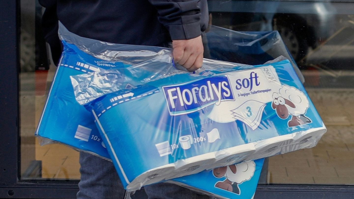 Mann trägt Packungen mit Toilettenpapier