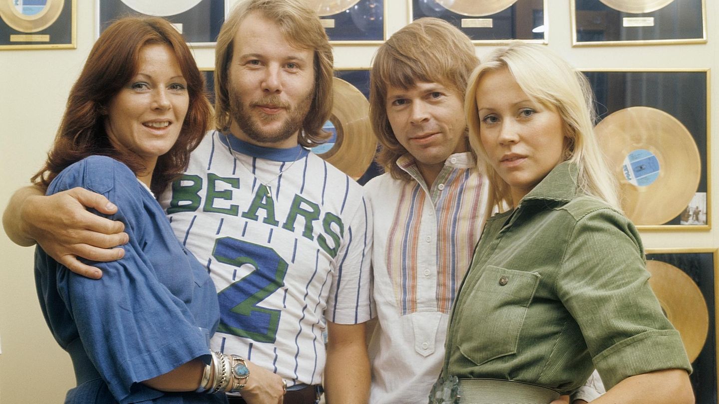 Die Gruppe Abba steht vor einer Wand mit goldenen Schallplatten