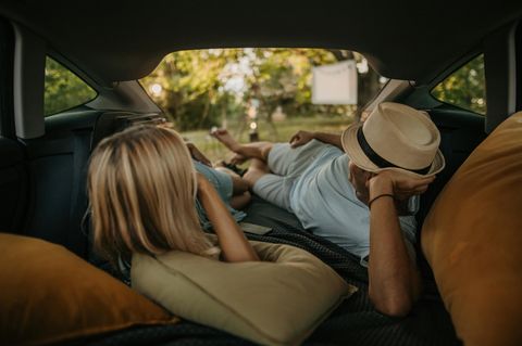 Zwei Menschen liegen auf einer Matratze fürs Auto.