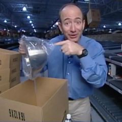 Jeff Bezos steht im Amazon Lager 1995 und hält eine silberne Schüssel in die Kamera