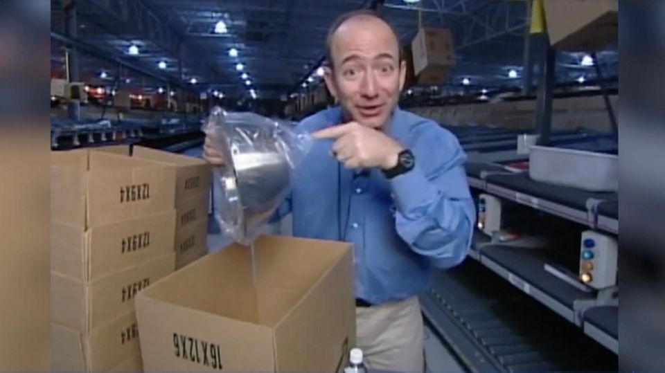 Jeff Bezos im Amazon Lager 1995 Jeff Bezos steht im Amazon Lager 1995 und hält eine silberne Schüssel in die Kamera