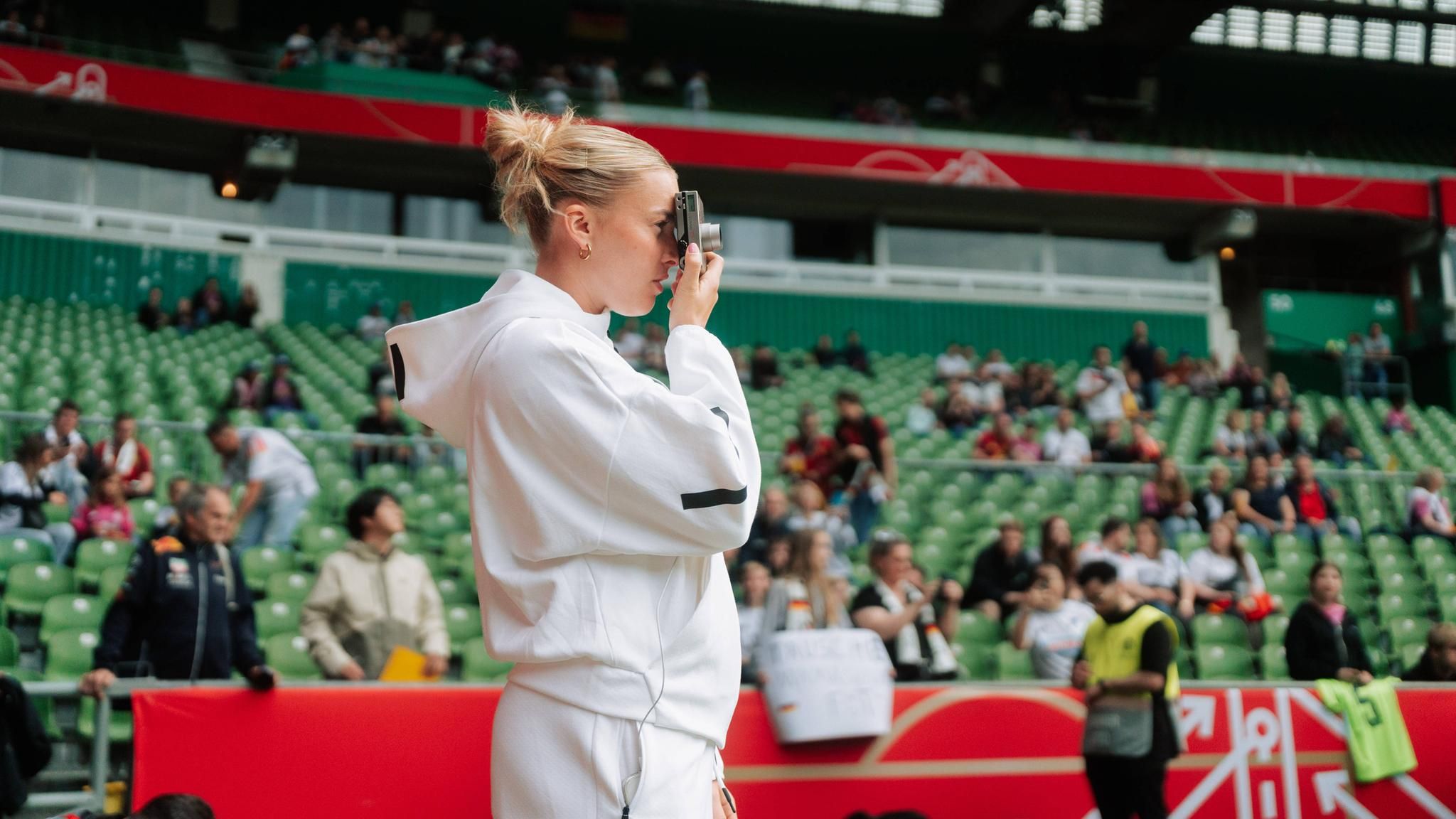 Laura Freigang blickt Ende Mai im Bremer Weserstadion vor einem DFB-Spiel durch ihre Kamera