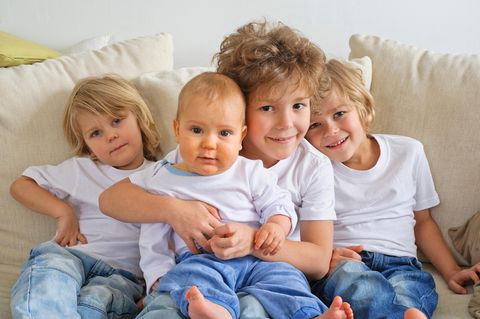 Babys: vier Brüder auf einem Sofa
