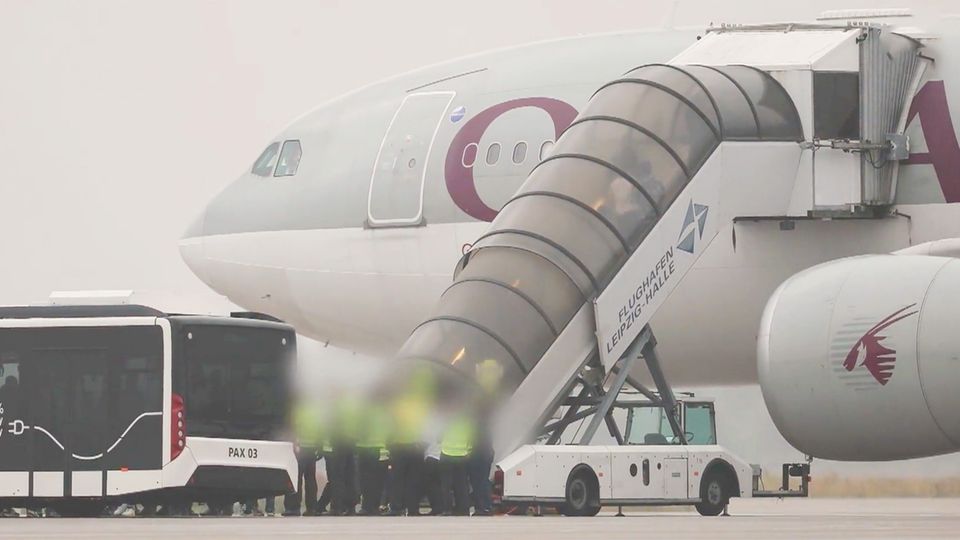 Deutschland schiebt 81 Straftäter nach Afghanistan ab zwei Polizisten stehen vor weiem Auto und sprechen mit dem Fahrer