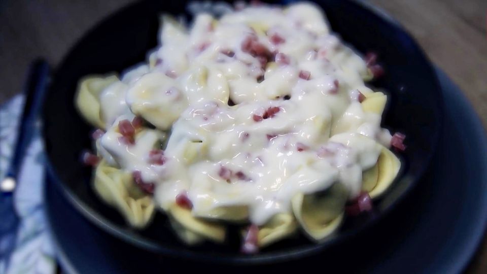 bakterienbefallende Tortellini bakterienbefallende Tortellini mit Schinken angerichtet auf einem dunklen Teller