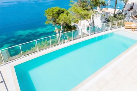 Ein Pool grenzt an das türkis-blaue Meer an Mallorcas Küste.