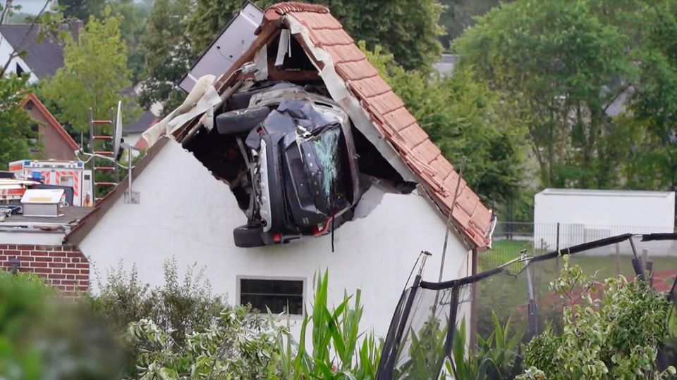 Ein Auto steckt in der Hauswand eines Einfamilienhaus in ein paar Metern Höhe. Ein Auto steckt in der Hauswand eines Einfamilienhaus in ein paar Metern Höhe.