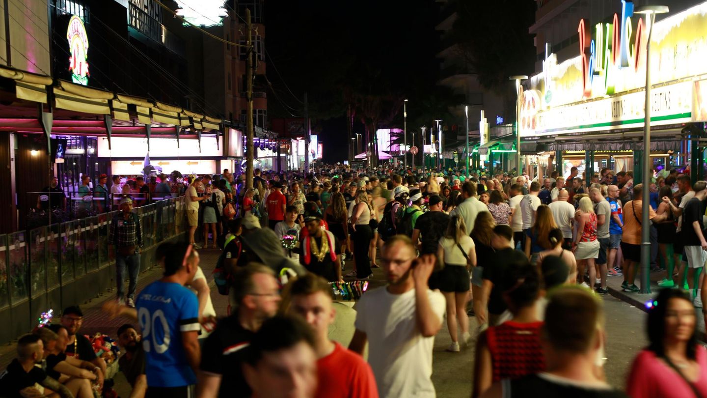 Touristen flanieren bei Nacht über die sogenannte Schinkenstraße auf Mallorca