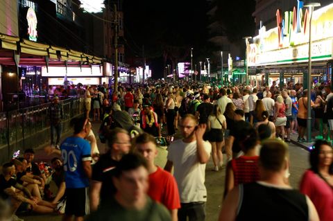 Touristen flanieren bei Nacht über die sogenannte Schinkenstraße auf Mallorca