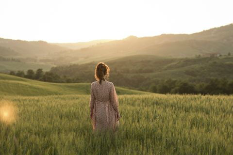 Frau steht in einem Feld