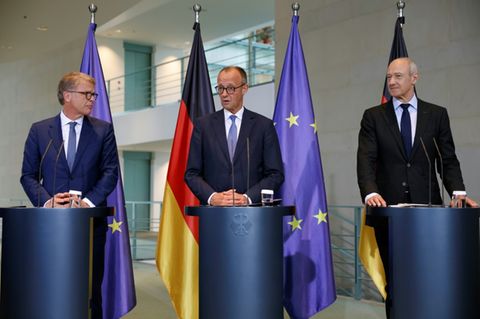 Christian Sewing (l.), Friedrich Merz und Roland Busch