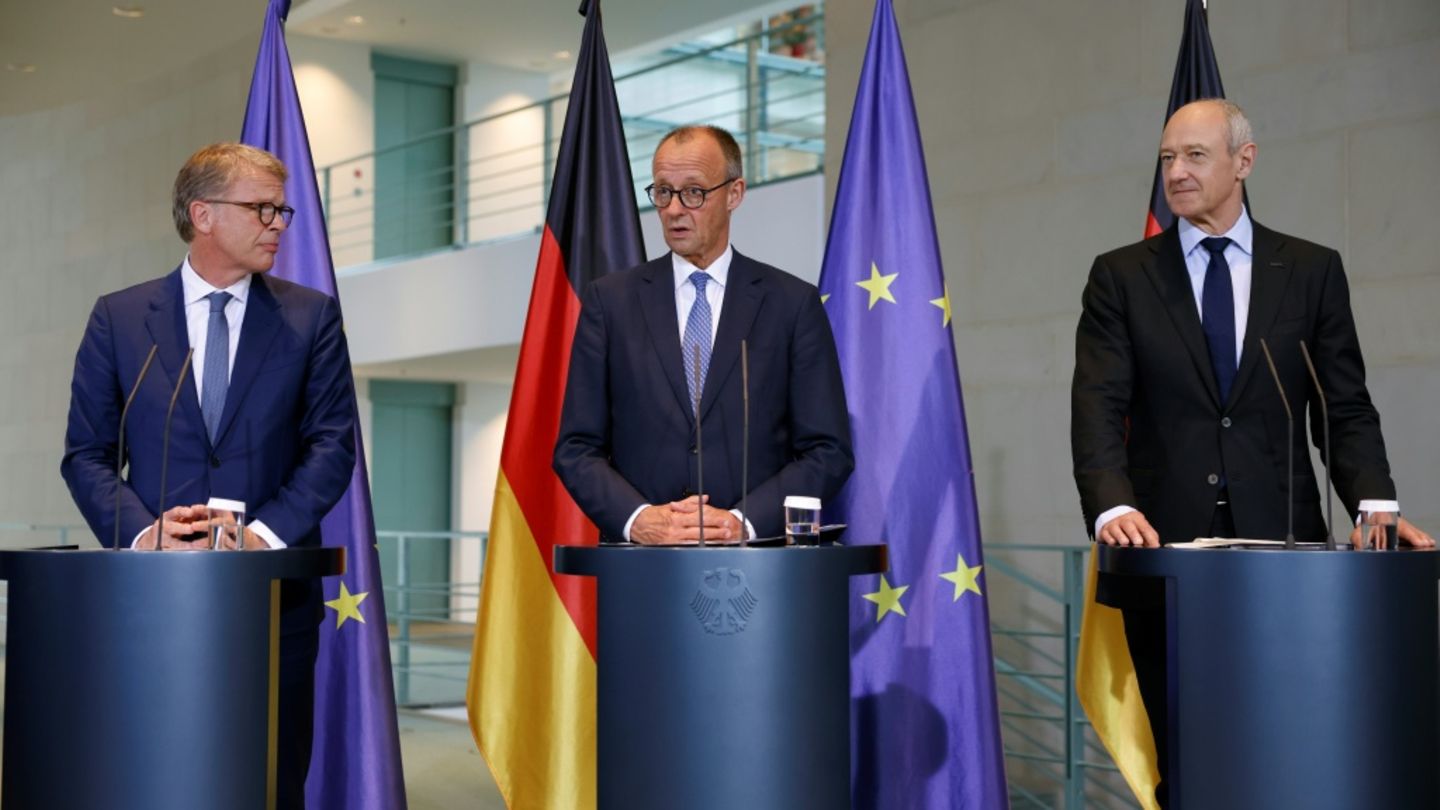 Christian Sewing (l.), Friedrich Merz und Roland Busch