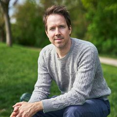 Christian Wunderlich blickt in die Kamera. Er hat kurze braune Haare und trägt einen grauen Pullover