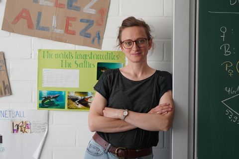 Unbesetzte Lehrerstellen: Die Lehrerin Ines Palm lehnt mit verschränkten Armen an einer Tafel.