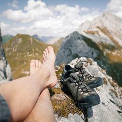 Austria, Tyrol, point of view shot of man's legs in mountainscape