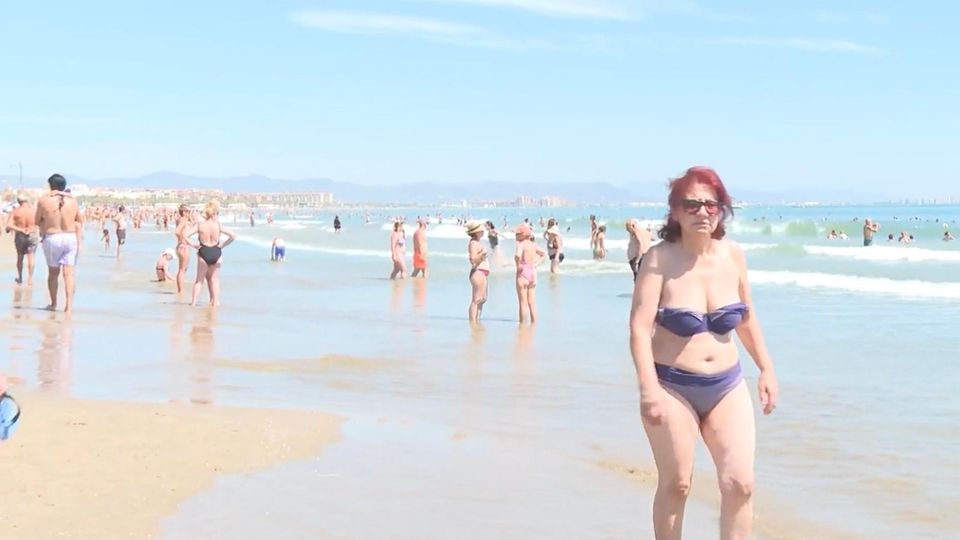 Hitze in Südeuropa Zahlreiche Menschen stehen in Badekleidung am Strand und im Wasser in Südeuropa.