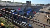 Rettungskräfte und Polizisten stehen am Tunnelausgang der Loveparade in Duisburg