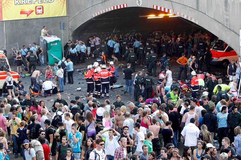 Loveparade Duisburg 2010: Rettungskräfte versorgen verletzte Menschen am Unglücksort auf dem Festival-Gelände