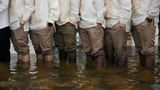 Trauzeugen und Gäste stehen knietief im Hochwasser und tragen den traditionellen Barong Tagalog