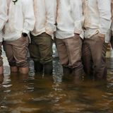 Trauzeugen und Gäste stehen knietief im Hochwasser und tragen den traditionellen Barong Tagalog