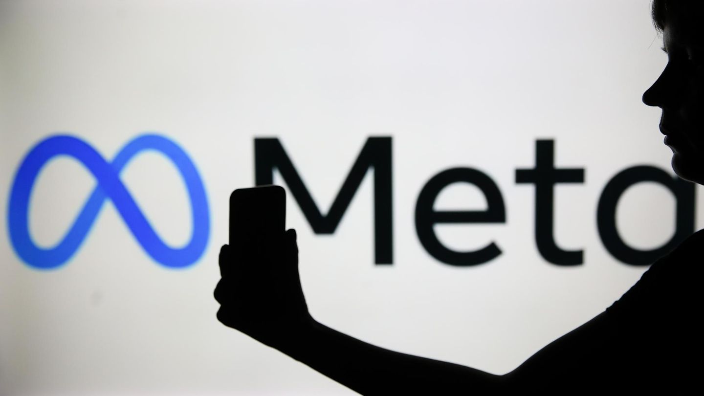 Der Schatten einer Frau mit Smartphone liegt vor dem Logo von Meta, dem Mutterkonzern von Facebook und Instagram Der Schatten einer Frau mit Smartphone liegt vor dem Logo von Meta, dem Mutterkonzern von Facebook und Instagram