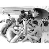 Männer am Strand um einen Strandkorb versammelt