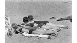 Vier Frauen am sonnen im Sandstrand