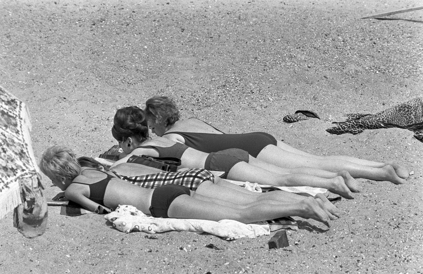 Vier Frauen am sonnen im Sandstrand