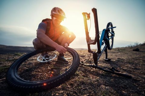 Mountainbiker repariert einen flachen Reifen