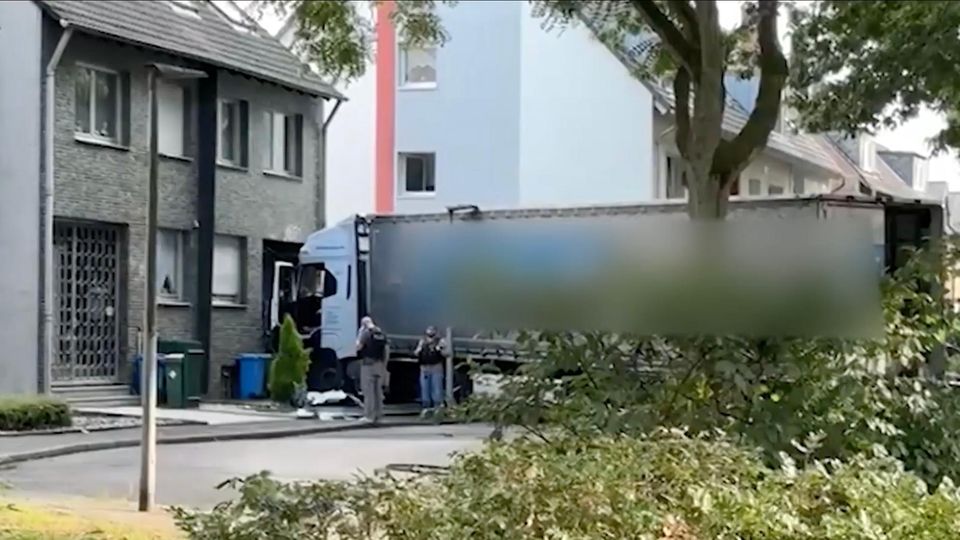 Ein weißer LKW kracht frontal in eine Wohnhauswand.