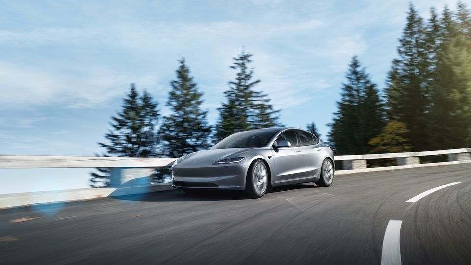 Ein silbernes Elektroauto fährt die Straße entlang.