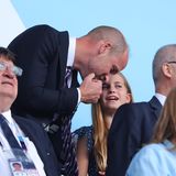 Prinz William beugt sich zu seiner Tochter gherunter und hört ihr zu