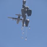 ... und wirft Hilfsgüter an Fallschirmen ab