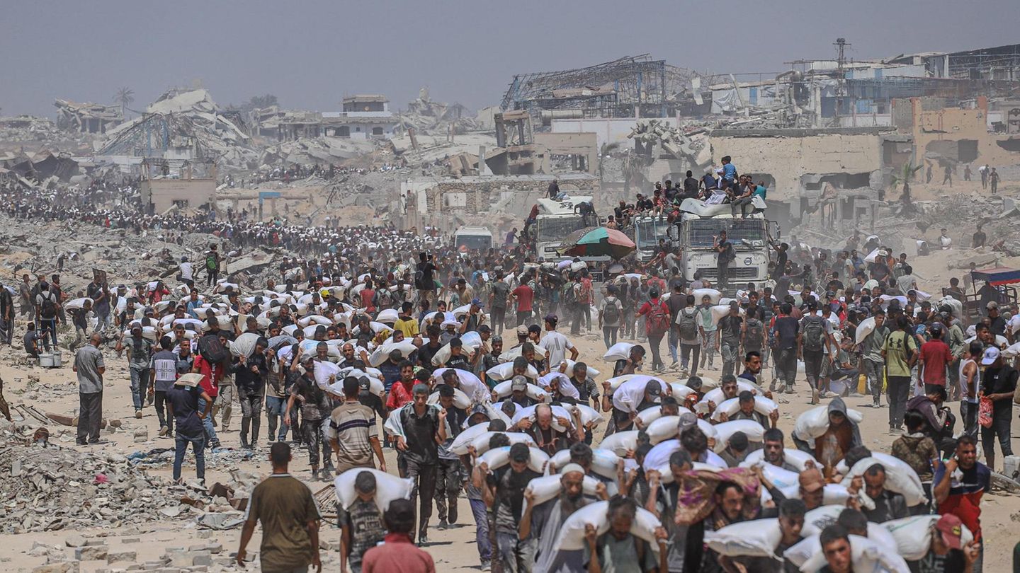 Ein Strom von Glücklichen mit Lebensmittel-Säcken auf den Schultern verlässt eine Verteilstelle bei al Sudaniya im Norden des Gazastreifens